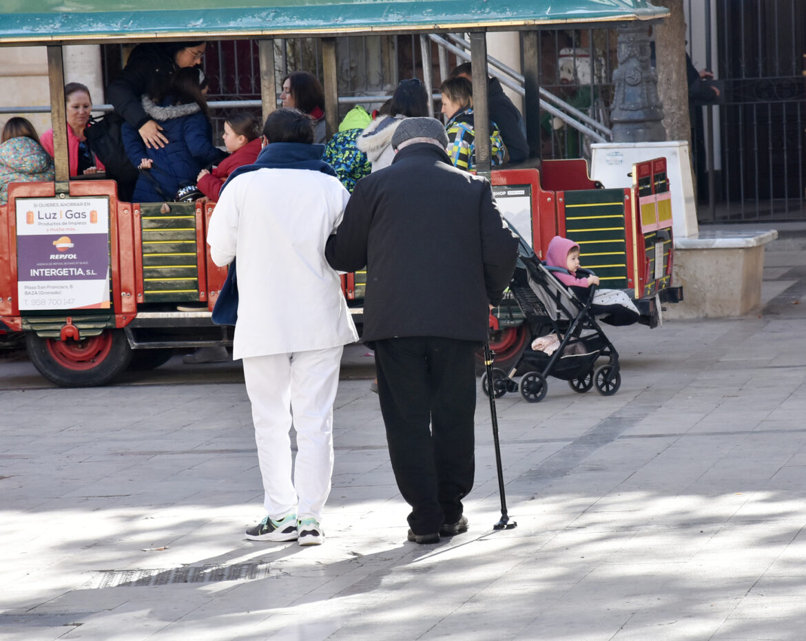 auxiliar de Ayuda a Domicilio paseando con un usuario en Baza